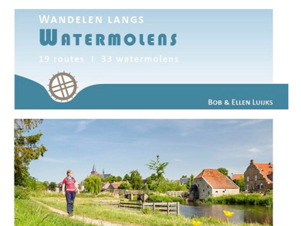 vrouw wandelt langs mooi landschap in Limburg langs de neerbeek.. In de verte is de Friedesse molen, een watermolen te zien
